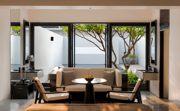 Pool Suite at Amansara with seated area overlooking gardens, Cambodia.