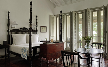 Principal bedroom at Amangalla with four-poster bed and colonial-style furnishings overlooking the verandah.