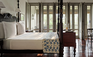 Principal bedroom at Amangalla with verandah doors, four-poster bed, and colonial-style furnishings.