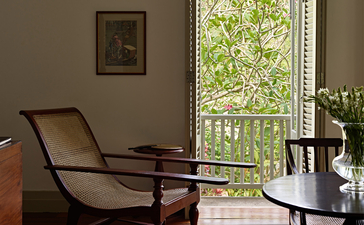 Verandah chamber at Amangalla with reclining chair overlooking tropical gardens, Sri Lanka.