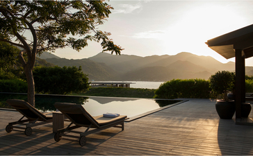 五间卧室住宅的露台在日落时俯瞰水景，安缦诺怡度假村。