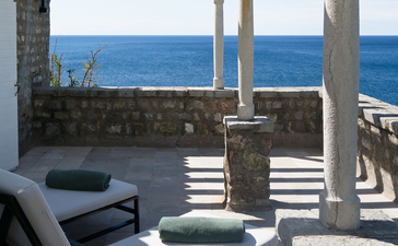 Adriatic Suite at Aman Sveti Stefan with sea views through columned terrace and loungers.