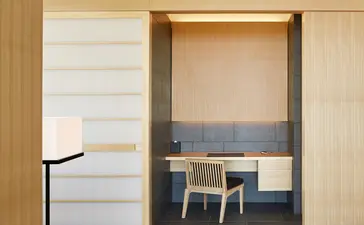 Aman Tokyo – seating area with wooden partitions and natural light filtering through frosted glass panels in a hotel suite.