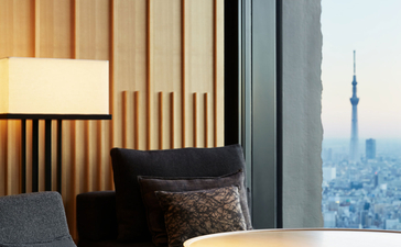 Galeria con asiento junto a ventana y vistas a Tokio en Aman Tokyo.