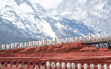 Amandayan's courtyard with snow-capped mountains and traditional red-roofed buildings with ornamental details.