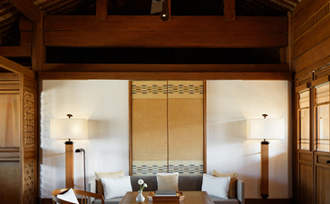 Wooden meditation pavilion at Amandayan with shoji screens, dark timber beams, and minimalist furnishings.