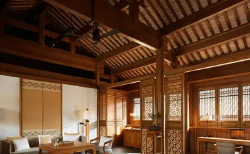 Principal bedroom at Amandayan with wooden ceiling beams, traditional furnishings, and large windows overlooking the landscape.