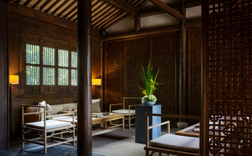 Serene wellness space at Amanfayun with wooden architecture, potted plant, and traditional furnishings.