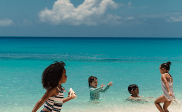 Enfants jouant dans les eaux turquoise d'Amanyara, resort aux Turques-et-Caïques.