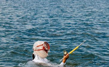 Hotel guest swimming in the calm bay at Amanemu resort.