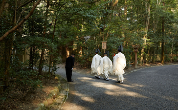Guests walking along a tree-lined pathway at Amanemu resort.