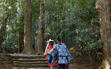 Visitors walking along stone steps through a forested pathway at Amanemu resort.