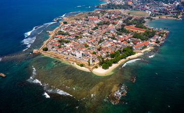 Aerial view of Amangalla's historic walled town surrounded by turquoise waters and rocky coastline.