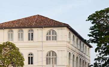 Cream-coloured colonial building at Amangalla with terracotta roof and arched windows.