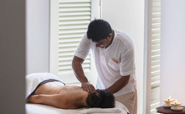 Therapist administers a massage treatment to a guest at Amangalla.
