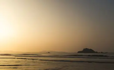 Sunrise over calm waters at Amangalla, with a distant island silhouetted against the golden sky.