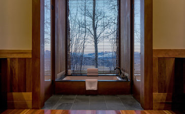 Deluxe Suite at Amangani with floor-to-ceiling windows framing winter landscape views.