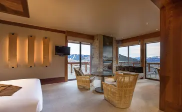 Gros Ventre Suite at Amangani with bed, seating area, and mountain views through floor-to-ceiling windows.
