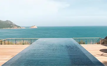 Infinity pool overlooking turquoise waters and coastal landscape at Amanoi, Vietnam.