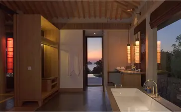 Ocean Pool Villa bathroom at Amanoi with soaking tub overlooking Vietnamese coastline at dusk.