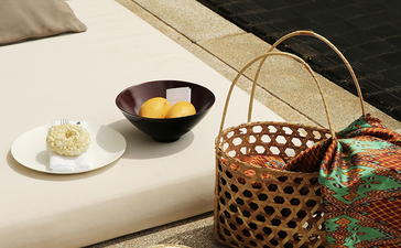 Amansara bedroom detail with woven basket, decorative hat and bedside offerings.