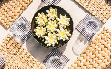 Overhead view of a plated salad at Amansara, surrounded by place settings and woven textiles.