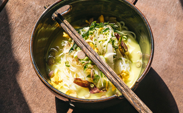 Bowl of noodle soup with chopsticks at Amansara, viewed from above.