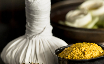 Herbal poultice and golden powder in bowls at Amansara's spa treatment area.