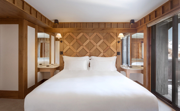 Chambre junior avec lit double, boiseries géométriques et portes-fenêtres, Aman Le Mélézin.