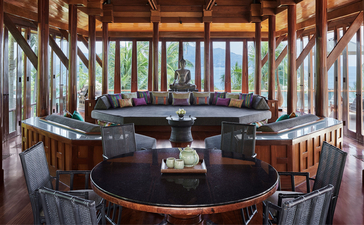 Eight-bedroom garden villa's open-sided pavilion with curved wooden bar and garden views at Amanpuri, Thailand.