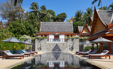 Giardino della villa con piscina, padiglioni tailandesi e lettini presso Amanpuri.