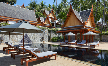 Terrazza di una villa con otto camere circondata da palme e architettura tailandese tradizionale presso il resort Amanpuri.