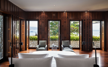 Eight-bedroom ocean villa at Amanpuri with open doors framing sea views and tropical landscape.