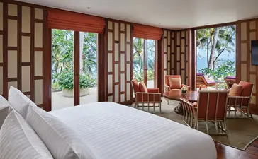 Principal bedroom with ocean views at Amanpuri resort, Thailand, featuring wooden-framed doors and terracotta furnishings.