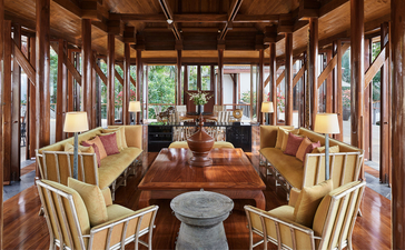 五间卧室海滨别墅的宽敞起居室,安缦璞瑞度假村,泰国,配有木质天花板、落地窗和传统家具。