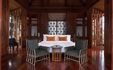 Salle à manger aux portes vitrées en bois dur d'une villa à Amanpuri.