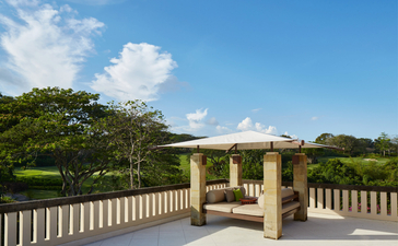 Five-bedroom villa with cream pavilion and wooden railings overlooking tropical gardens at Aman Villas at Nusa Dua, Bali.