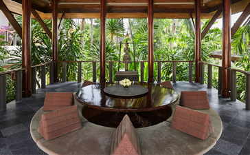Four-bedroom garden villa lounge at Amanpuri with circular seating area overlooking tropical gardens.