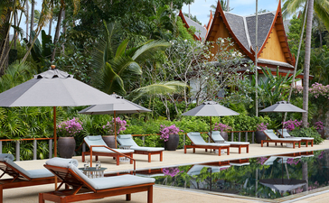 Four-bedroom garden villa with teak loungers and white umbrellas at Amanpuri, Thailand.