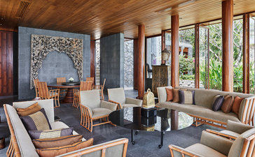 安缦璞瑞度假村四卧海景别墅宽敞客厅,配木梁天花板、舒适座椅和落地窗景观。