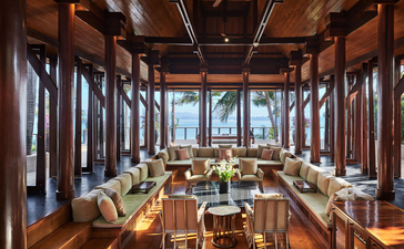 安缦璞瑞度假村四卧海景别墅的餐厅，木质天花板和大窗户俯瞰海景。