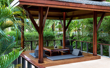 Pavilion with timber frame at Amanpuri resort, featuring a plunge pool and wooden decking surrounded by tropical vegetation.