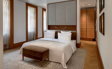 Milocer Garden View Suite principal bedroom at Aman Sveti Stefan with canopied bed and wooden furnishings.