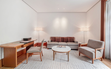 Milocer Garden View Suite lounge at Aman Sveti Stefan, with mid-century furniture and natural light from large windows.