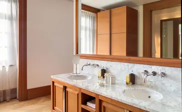 Milocer Garden View Suite bathroom at Aman Sveti Stefan with wooden cabinetry and marble vanity.
