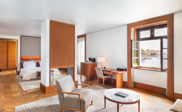 Sea View Suite bedroom at Aman Sveti Stefan with wooden furnishings and Adriatic vistas.