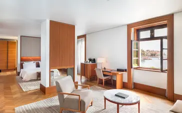 Sea View Suite bedroom at Aman Sveti Stefan with wooden furnishings and Adriatic vistas.