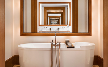 Circular mirror above a freestanding bathtub in the Sea View Suite at Aman Sveti Stefan, Montenegro.
