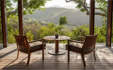 Wooden pavilion with two chairs overlooking mountainous landscape at Amanoi, Vietnam.