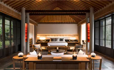 Mountain Pavilion at Amanoi with wooden ceiling, central seating area, and framed views to landscape beyond.